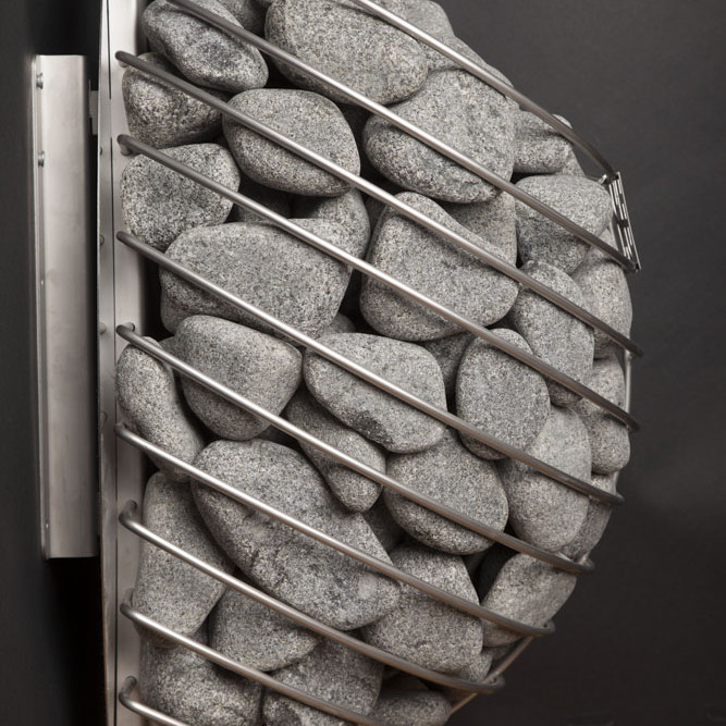 Side Profile Of A Wall-Mounted Huum Drop Electric Sauna Heater Filled With Sauna Stones, Showing How Far It Projects From The Wall.